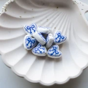 Perlina cuore in ceramica 15x14,5 mm - motivo a fiocco - Bianco - Blu x1