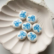 Perla ovale in ceramica 19x16 mm - motivo a fiocco - Bianco - Blu x1