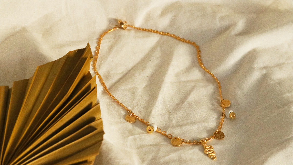 Schema Collana Charlotte placcata in oro con ciondoli di serpente in oro zecchino, paillettes e perline heishi in ceramica Schema Collana Charlotte placcata in oro con ciondoli di serpente in oro zecchino, paillettes e perline heishi in ceramica