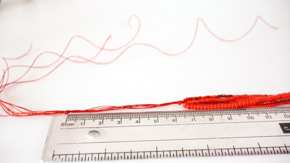 Bracciale a più fili con perle di semi rosse : Tappa 4 Bracciale a più fili con perle di semi rosse : Tappa 4