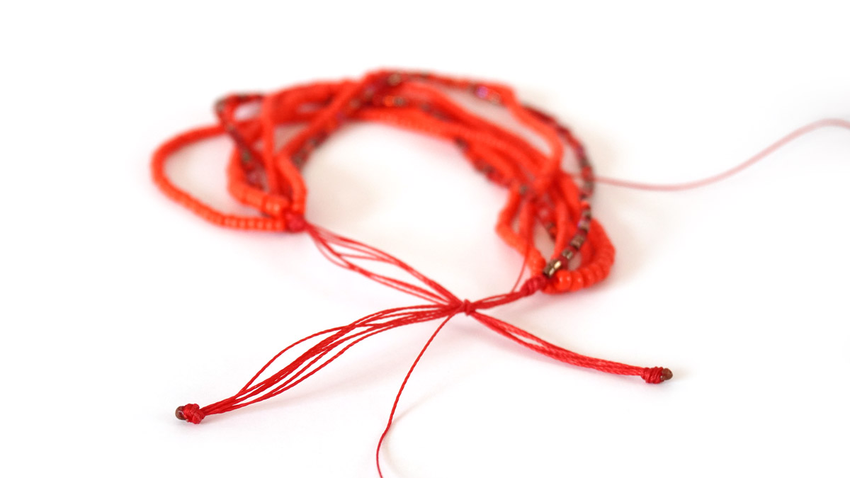 Bracciale a più fili con perle di semi rosse : Tappa 5 Bracciale a più fili con perle di semi rosse : Tappa 5