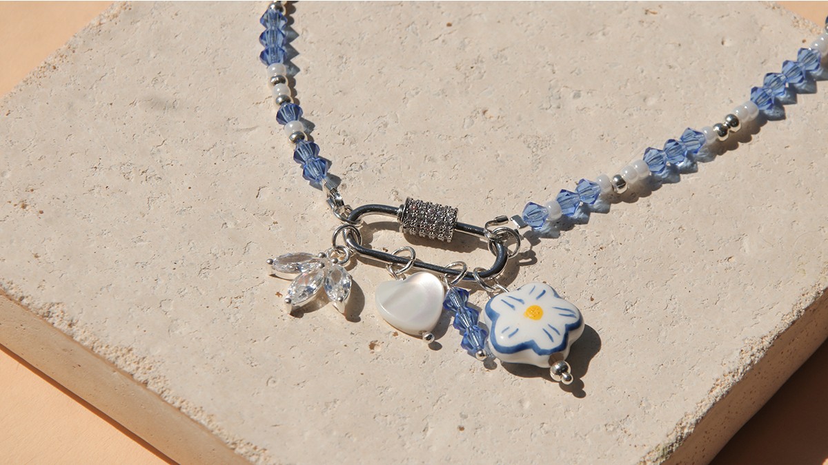 Collana con chiusura a moschettone, trottole blu e accumulo di ciondoli