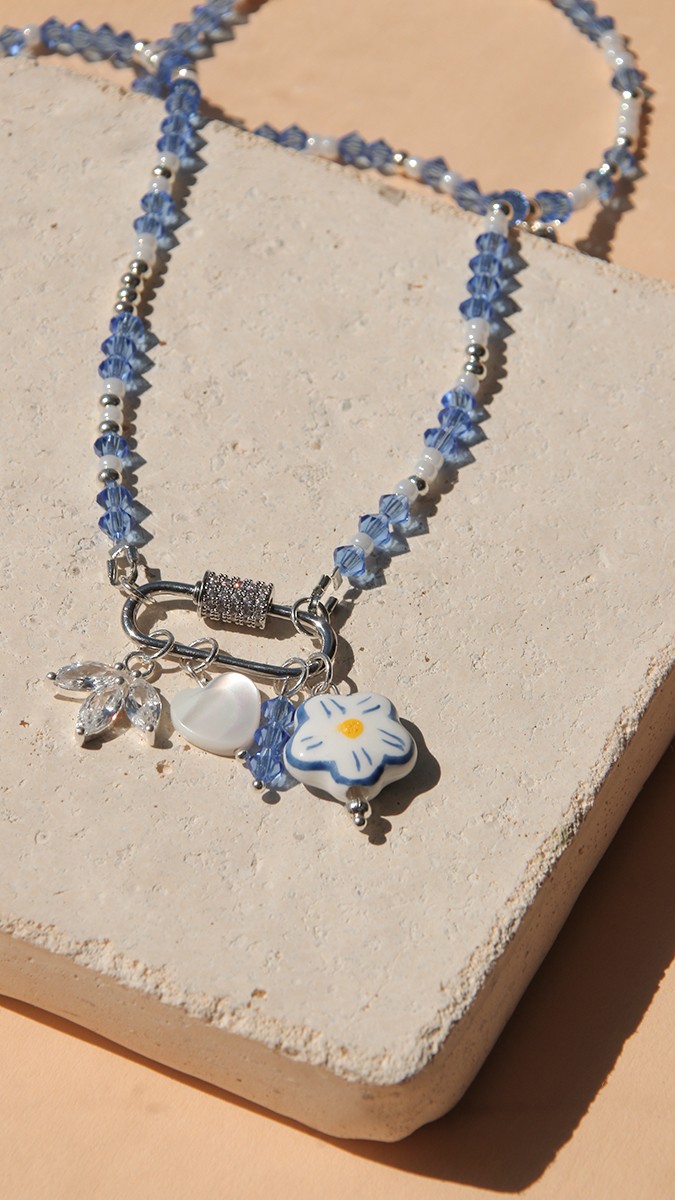 Schema Collana con chiusura a moschettone, trottole blu e accumulo di ciondoli