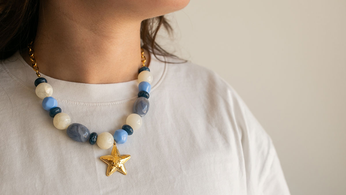 Collana di perle in resina con pendente dorato Collana di perle in resina con pendente dorato